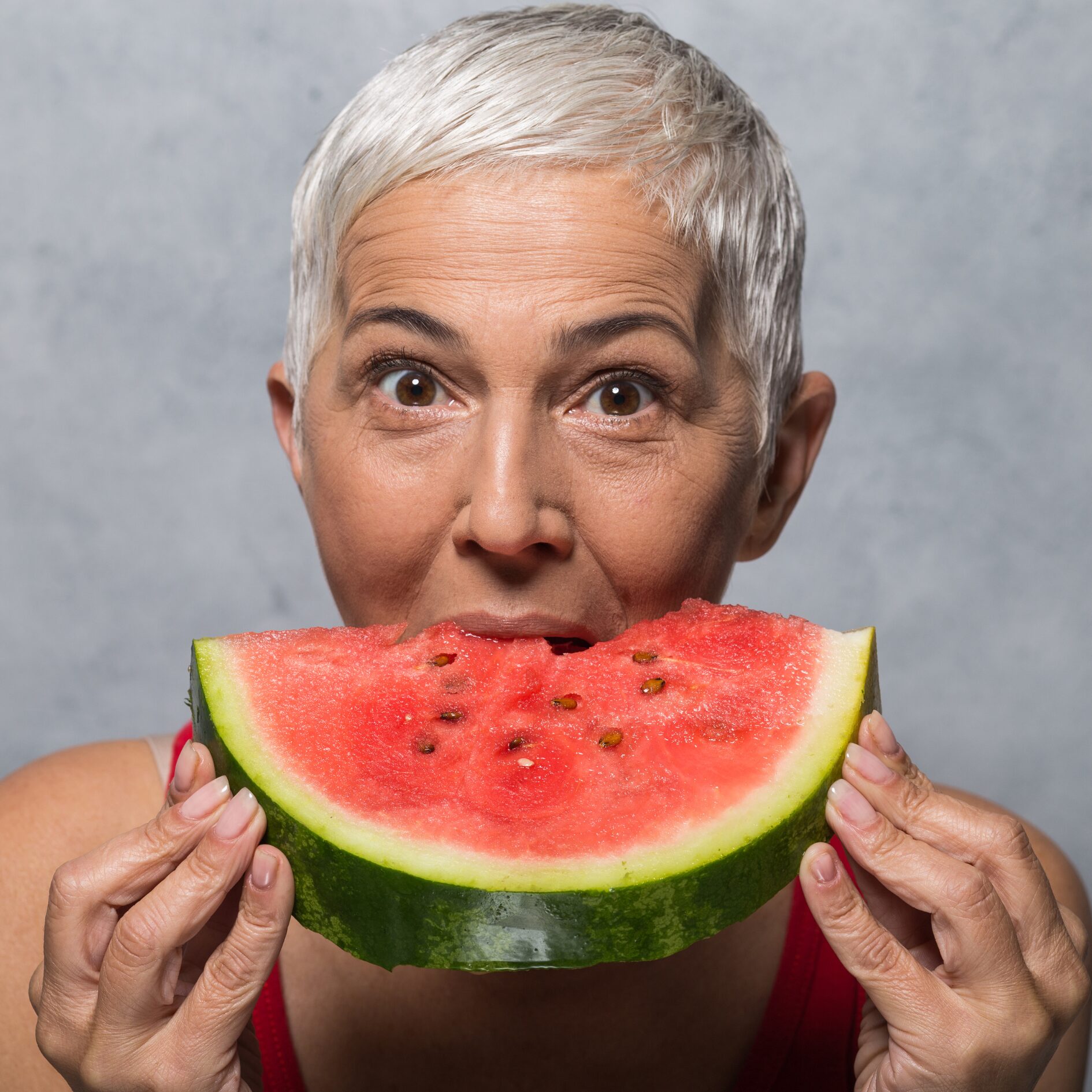 Frau isst Melone. Gesunde Ernährung ab 60 ist wichtig